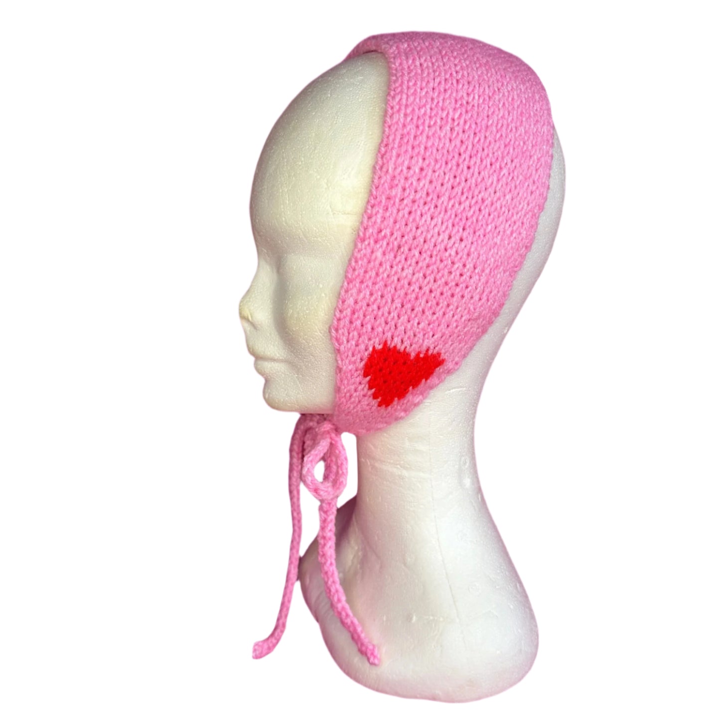 A pink knit style headband with a heart pattern displayed on a mannequin head.